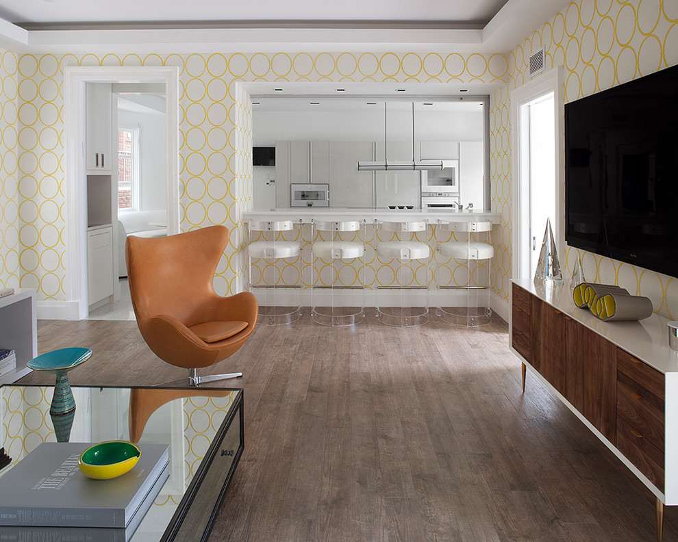 Réalisation d'une salle de séjour design ouverte avec un mur jaune, un sol en bois brun et un téléviseur fixé au mur.