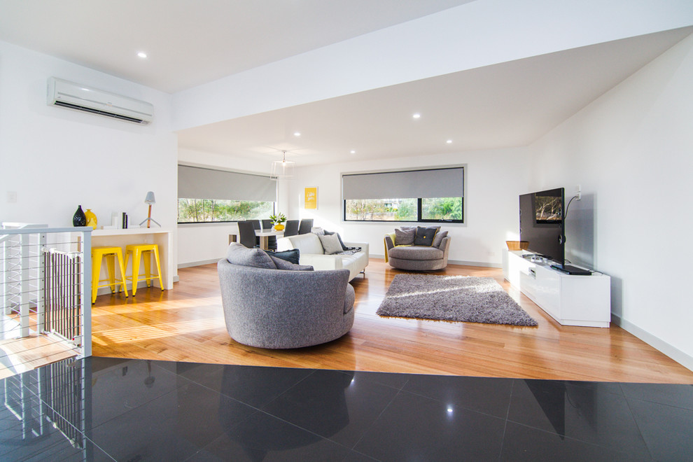 Mittelgroßes, Offenes Modernes Wohnzimmer ohne Kamin mit weißer Wandfarbe, hellem Holzboden und freistehendem TV in Hobart