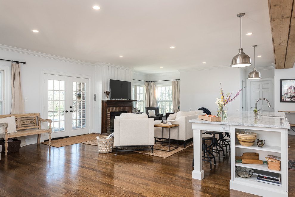 Diseño de sala de estar abierta clásica renovada de tamaño medio con suelo de madera en tonos medios, estufa de leña, marco de chimenea de ladrillo y suelo marrón
