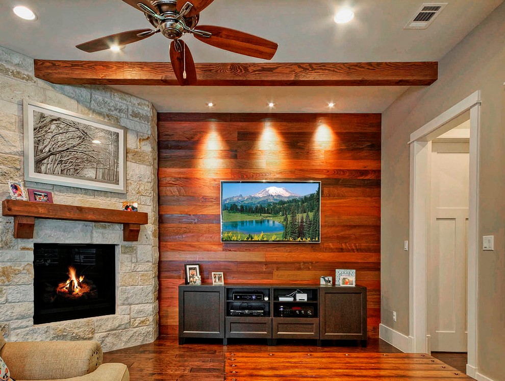 Mittelgroßes, Offenes Klassisches Wohnzimmer mit braunem Holzboden, Kamin, Kaminumrandung aus Stein und TV-Wand in Austin