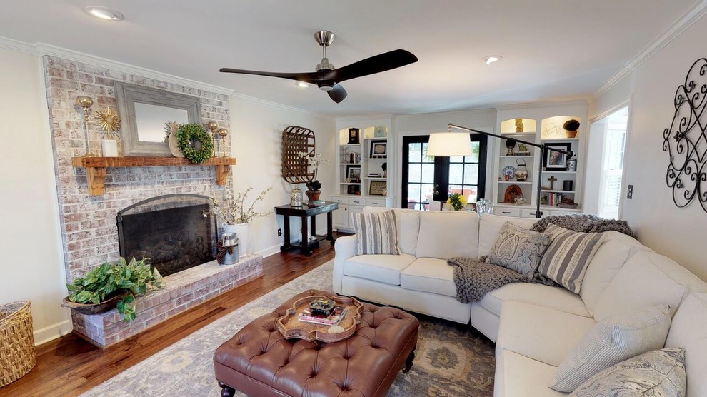 Example of a farmhouse open concept medium tone wood floor family room design in Other with white walls, a standard fireplace and a brick fireplace