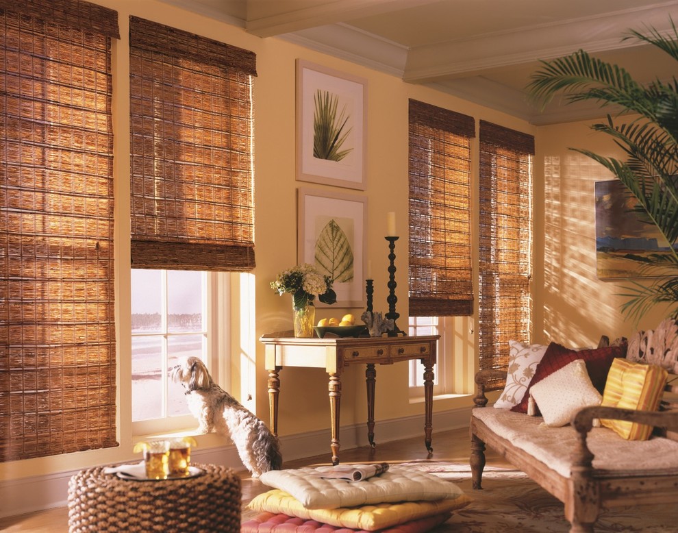 Modelo de sala de estar cerrada tropical grande sin chimenea con paredes amarillas y suelo de madera clara