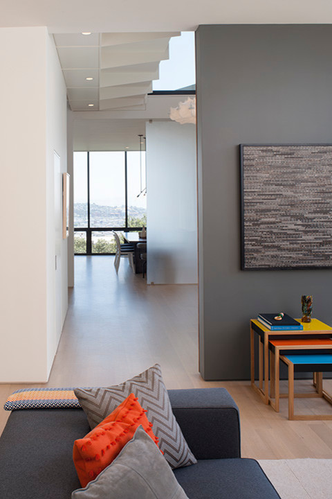 Inspiration för minimalistiska allrum med öppen planlösning, med grå väggar och ljust trägolv