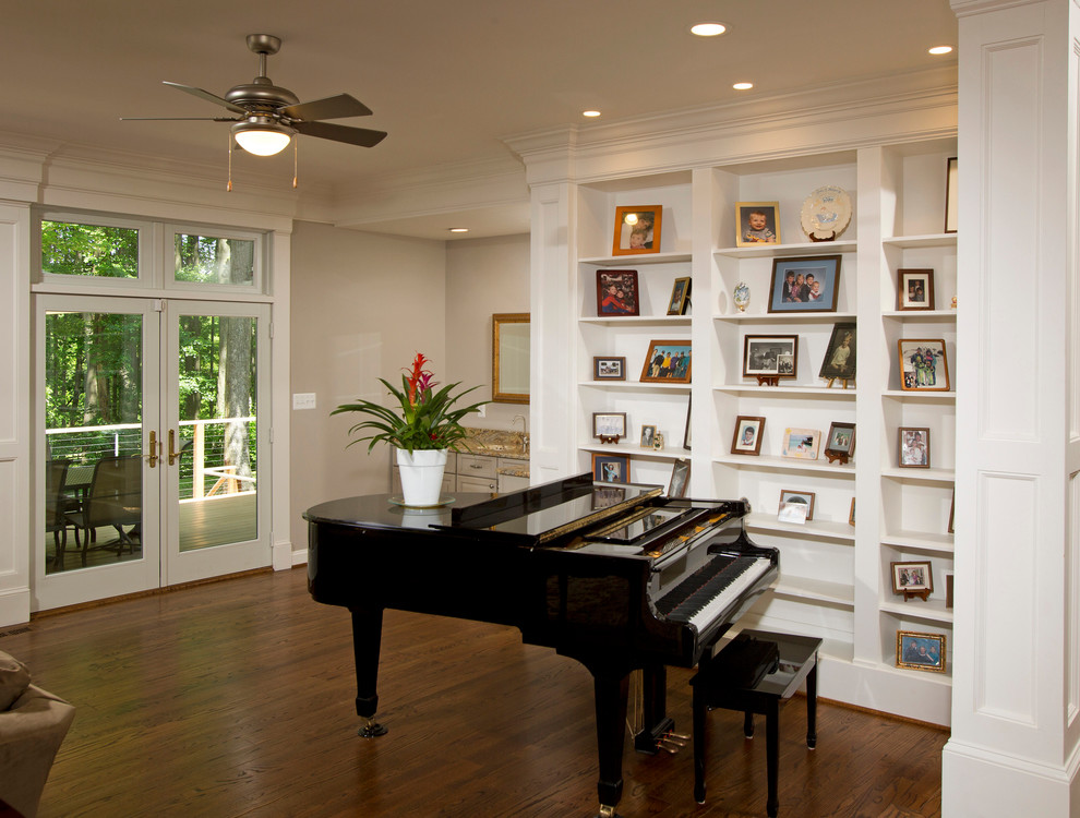 Ejemplo de sala de estar con rincón musical abierta tradicional grande con paredes beige y suelo de madera oscura