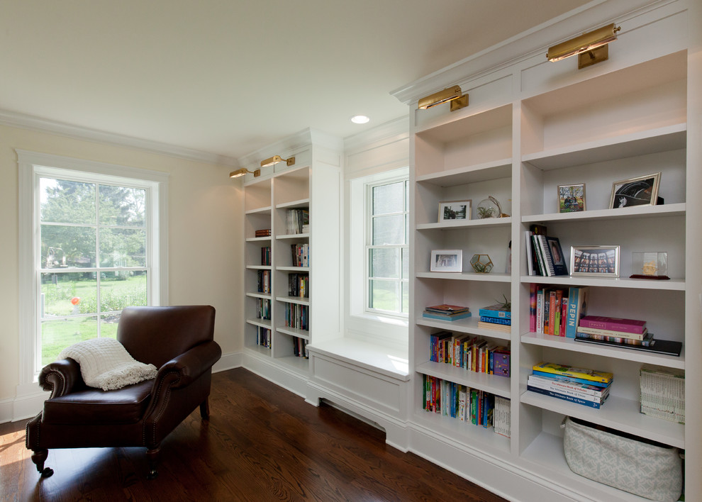 Foto de sala de estar con biblioteca abierta de estilo de casa de campo grande con paredes amarillas, suelo de madera en tonos medios y suelo marrón