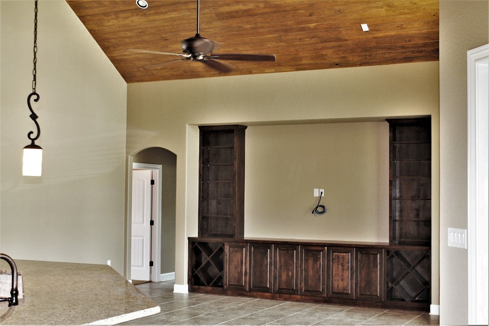 Стильный дизайн: большая открытая гостиная комната в классическом стиле с бежевыми стенами, полом из керамической плитки, телевизором на стене и бежевым полом - последний тренд