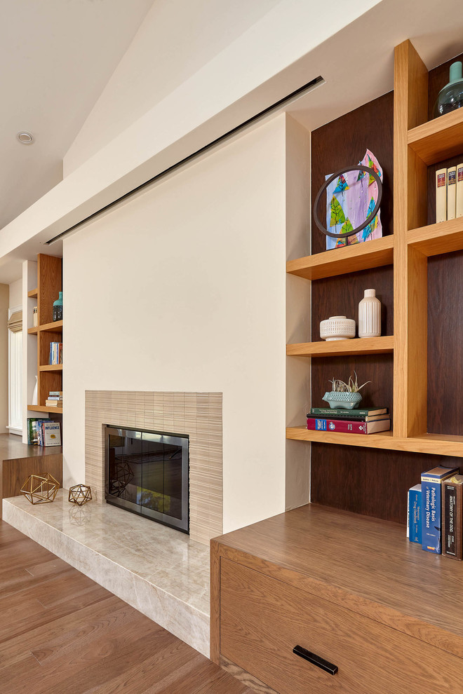 Photo of a large classic open plan games room in San Francisco with beige walls, medium hardwood flooring, a standard fireplace, a tiled fireplace surround and brown floors.