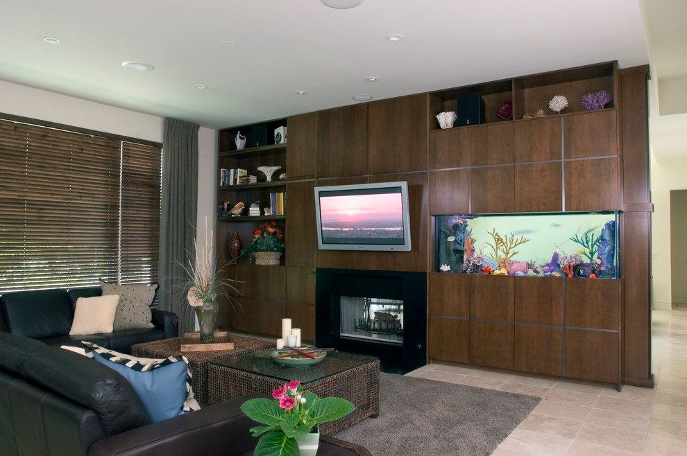 Example of a large trendy open concept limestone floor family room design in Chicago with beige walls, a two-sided fireplace, a stone fireplace and a wall-mounted tv