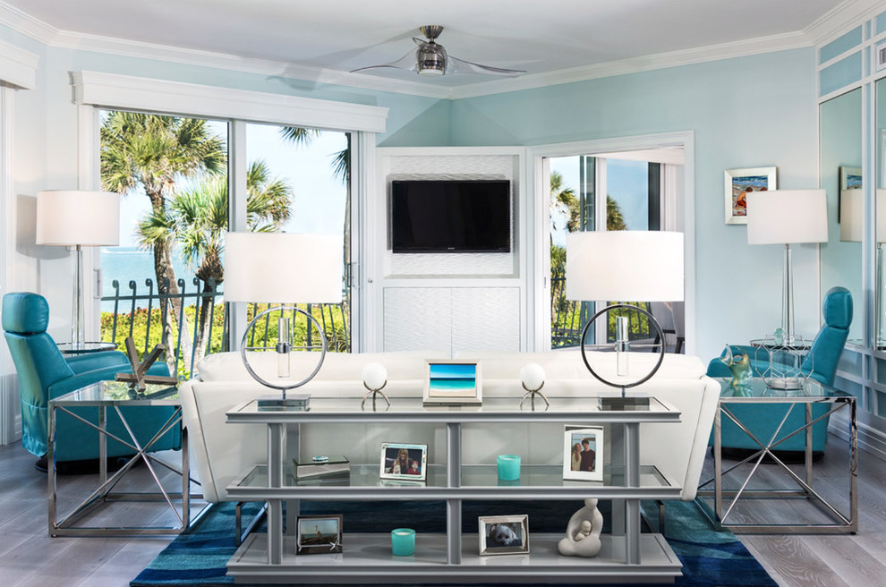 マイアミにある中くらいなビーチスタイルのおしゃれな独立型ファミリールーム (青い壁、濃色無垢フローリング、暖炉なし、壁掛け型テレビ、グレーの床) の写真