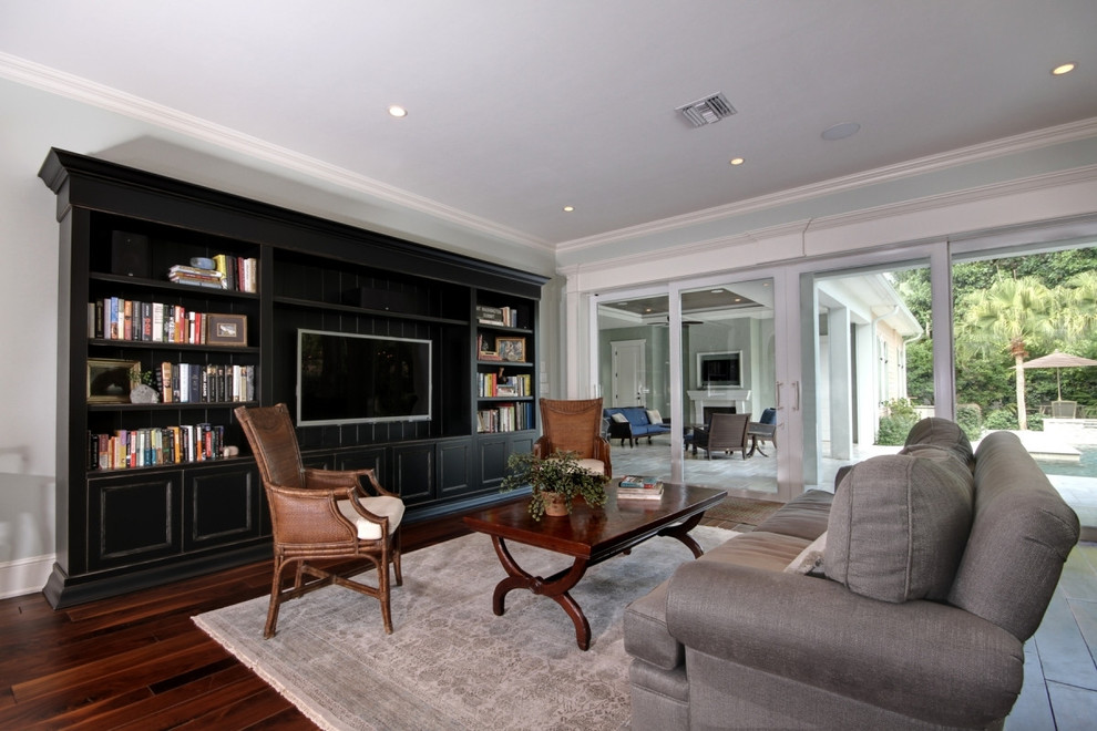 Photo of a large traditional enclosed games room in Miami with grey walls, dark hardwood flooring, no fireplace, a built-in media unit and brown floors.