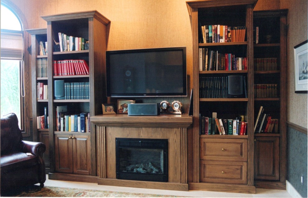 Family room library - transitional light wood floor family room library idea in Tampa with beige walls, a standard fireplace, a metal fireplace and a wall-mounted tv