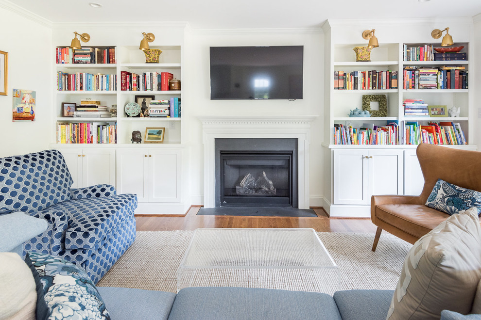 Ejemplo de sala de estar tradicional con paredes blancas, suelo de madera en tonos medios, televisor colgado en la pared, todas las chimeneas y suelo marrón