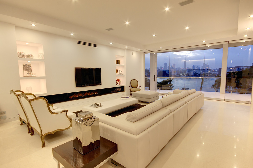 Ejemplo de sala de estar abierta minimalista extra grande con paredes blancas, suelo de travertino, chimenea lineal, marco de chimenea de metal y televisor colgado en la pared