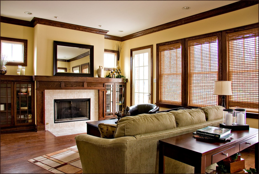 Imagen de sala de estar abierta de estilo americano con todas las chimeneas, marco de chimenea de baldosas y/o azulejos, paredes beige y suelo de madera en tonos medios