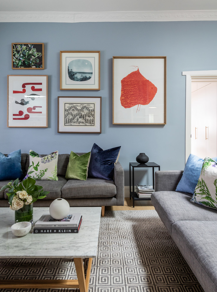 Eklektisches Wohnzimmer mit blauer Wandfarbe und hellem Holzboden in Sydney