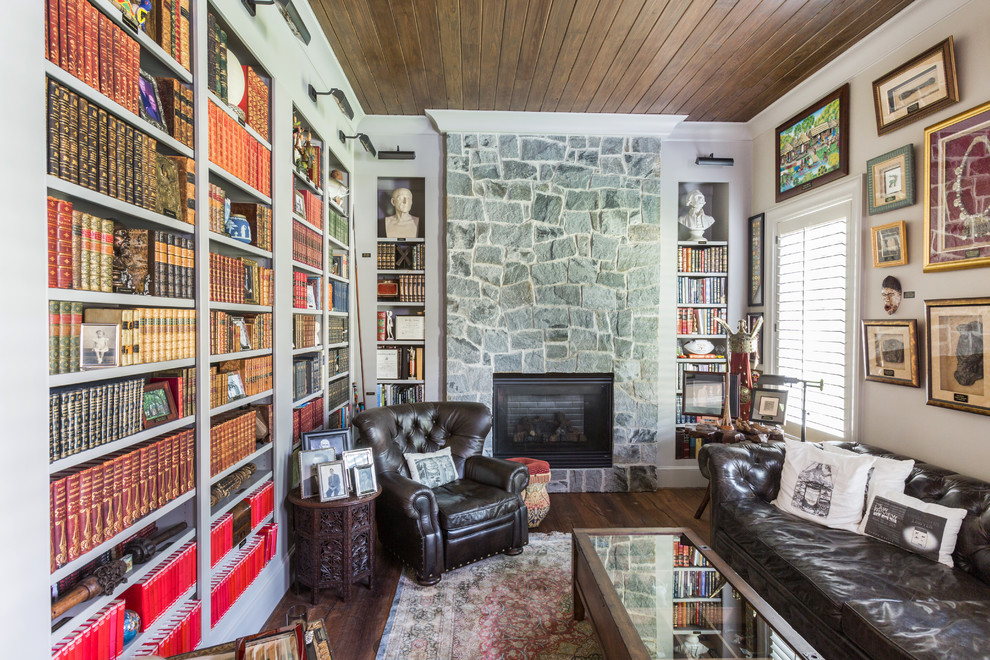 Modelo de sala de estar con biblioteca tradicional con suelo de madera oscura, paredes beige y todas las chimeneas