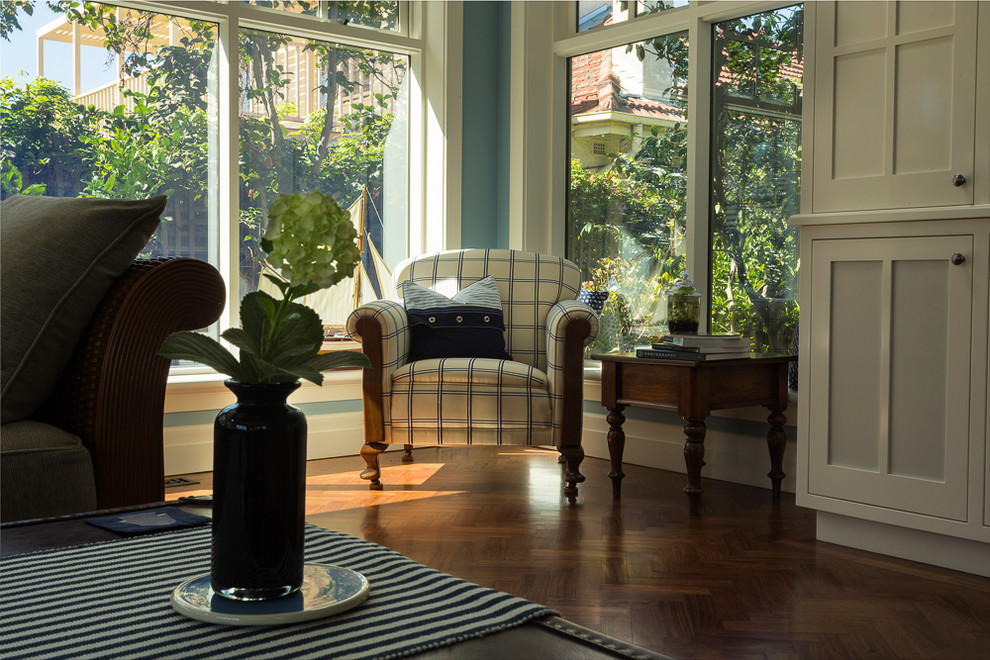 Immagine di un grande soggiorno stile americano aperto con pareti blu, pavimento in legno massello medio e parete attrezzata