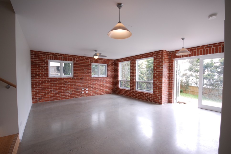 Foto de sala de estar abierta contemporánea de tamaño medio con paredes beige, suelo de madera clara, estufa de leña, marco de chimenea de baldosas y/o azulejos y suelo marrón