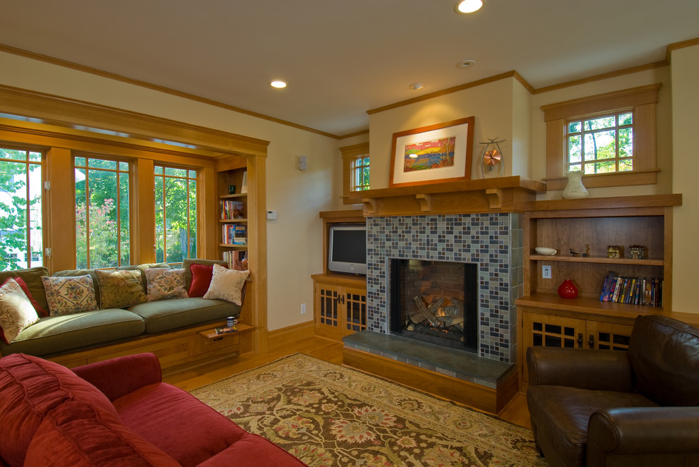 Idée de décoration pour un salon craftsman de taille moyenne avec un manteau de cheminée en carrelage, un mur beige, un sol en bois brun et une cheminée standard.