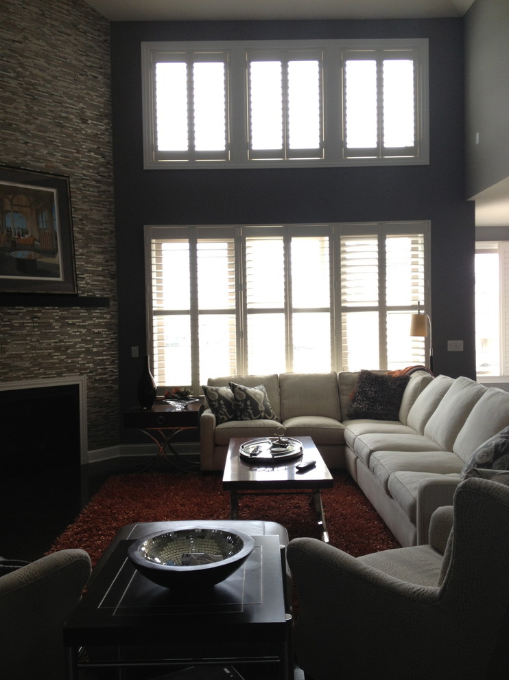 Immagine di un soggiorno chic di medie dimensioni e aperto con pareti grigie, camino ad angolo, cornice del camino piastrellata e nessuna TV