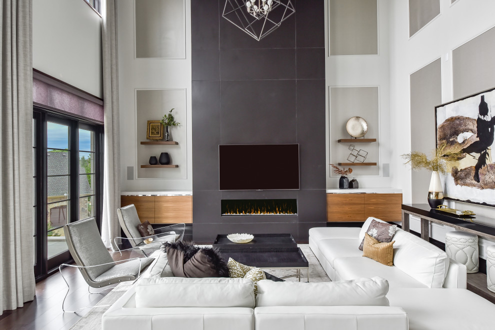 Diseño de sala de estar abierta contemporánea grande con paredes blancas, suelo de madera oscura, chimenea lineal, marco de chimenea de baldosas y/o azulejos, televisor colgado en la pared, suelo marrón y panelado