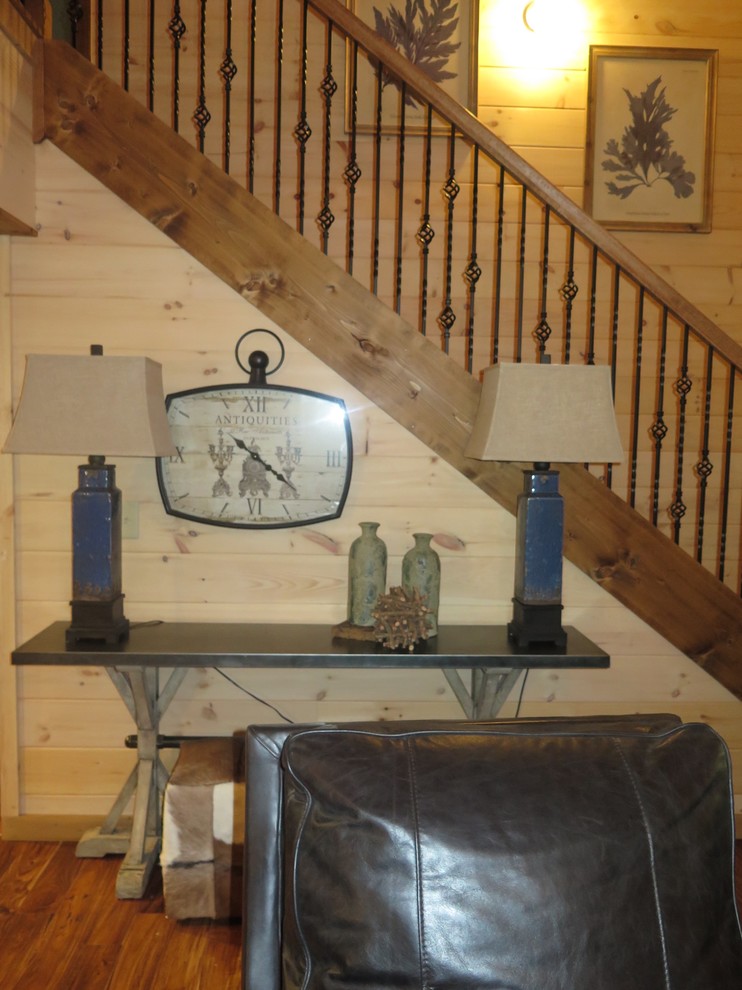 Ejemplo de sala de estar abierta rústica pequeña con chimenea de esquina, marco de chimenea de piedra y suelo de madera en tonos medios