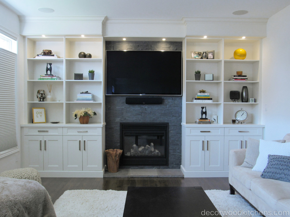 Example of a trendy dark wood floor game room design in Toronto with white walls, a standard fireplace, a stone fireplace and a media wall