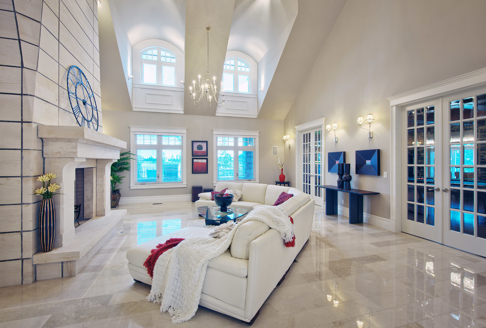 Esempio di un grande soggiorno tradizionale aperto con pareti beige, pavimento in marmo, camino classico, cornice del camino in pietra e nessuna TV