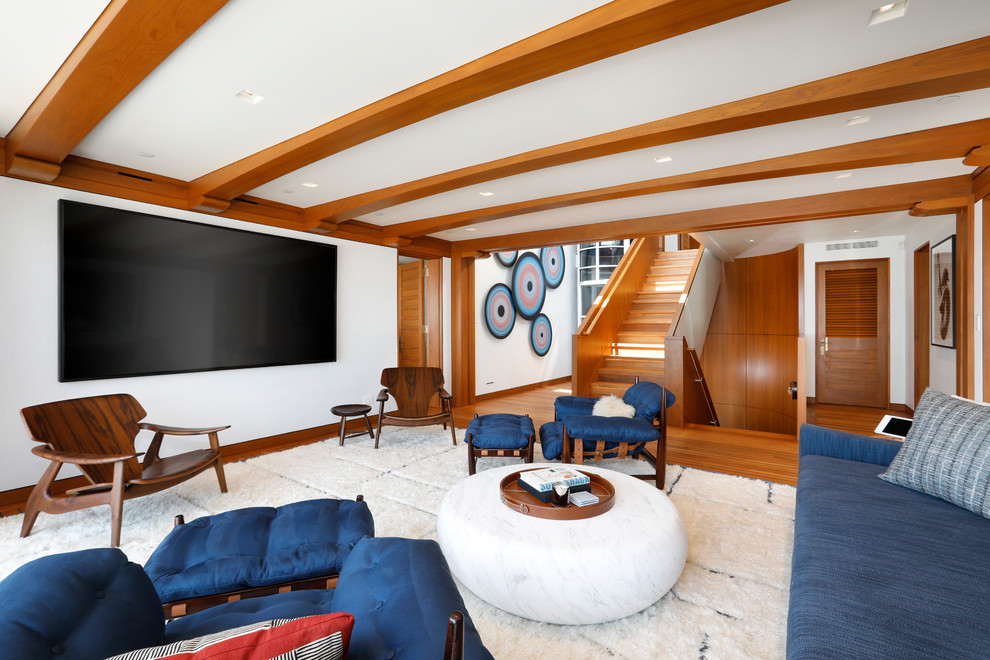 Diseño de sala de estar cerrada marinera de tamaño medio sin chimenea con paredes blancas, suelo de madera en tonos medios, televisor colgado en la pared y suelo marrón