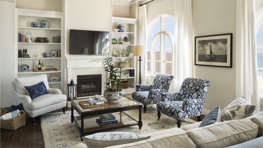 Photo of a medium sized coastal open plan games room in Los Angeles with beige walls, dark hardwood flooring, a standard fireplace, a plastered fireplace surround and a wall mounted tv.