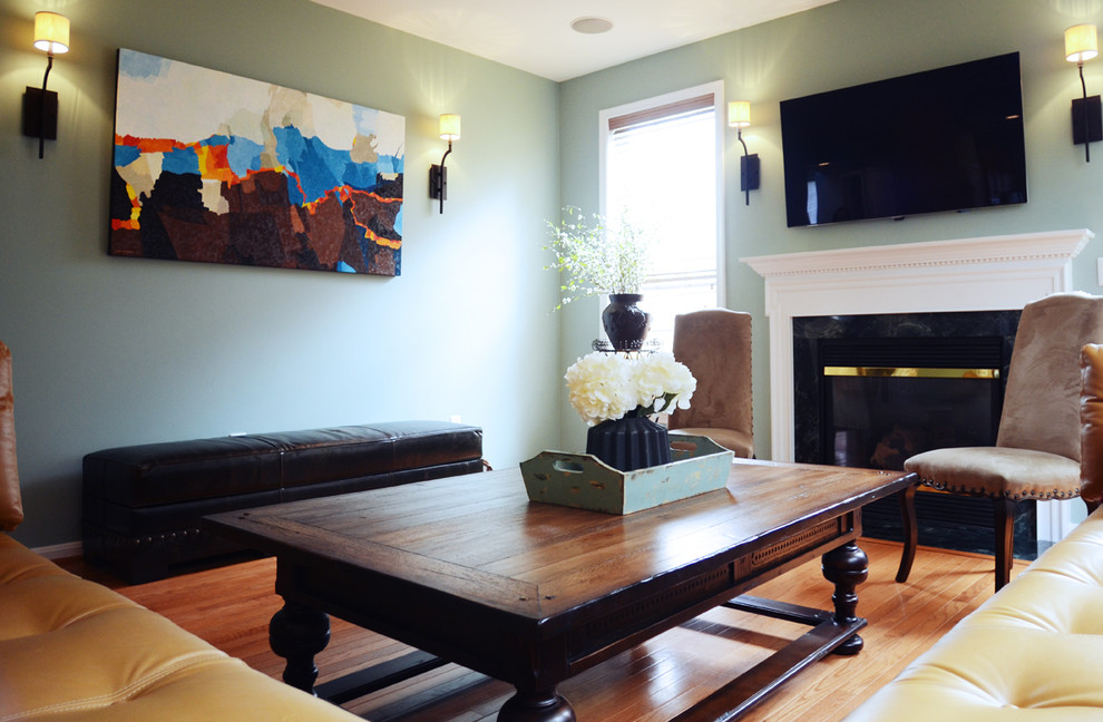 Inspiration pour une grande salle de séjour traditionnelle ouverte avec un mur bleu, parquet clair, une cheminée standard, un manteau de cheminée en carrelage et un téléviseur fixé au mur.