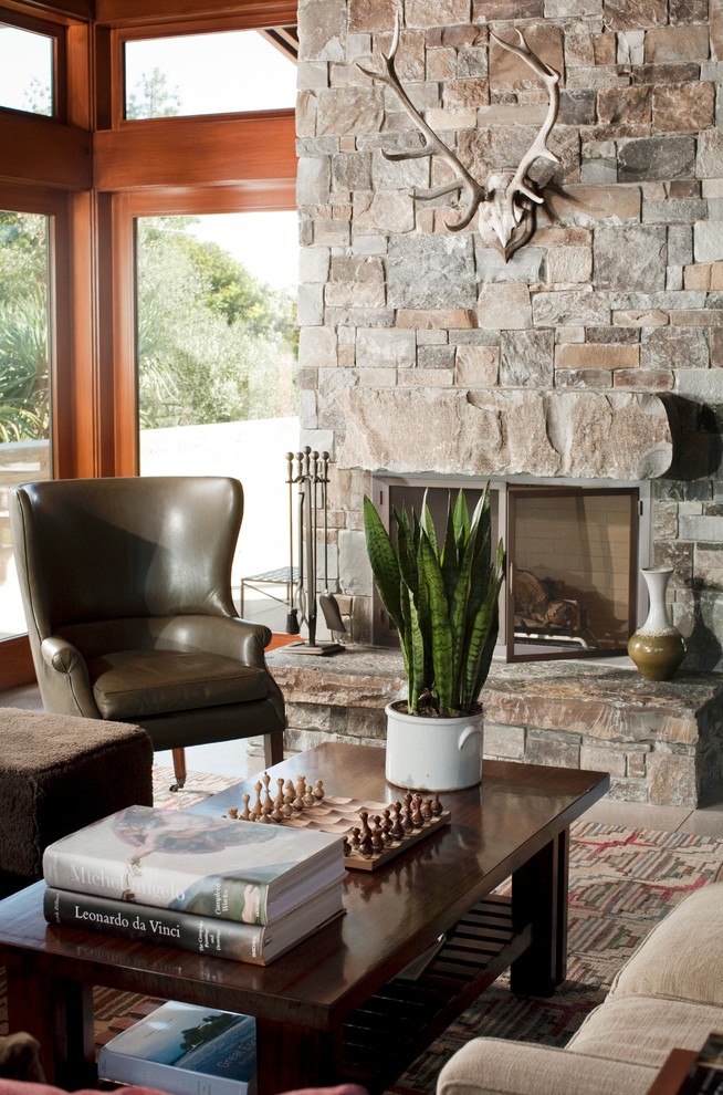 Design ideas for a bohemian games room in Los Angeles with a standard fireplace and a stone fireplace surround.
