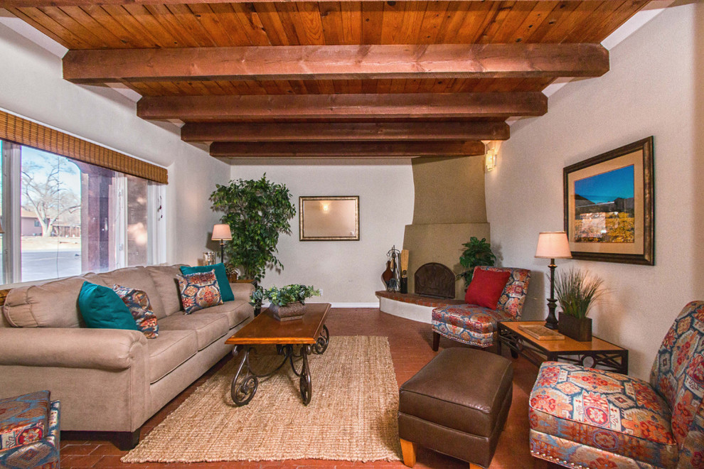Mittelgroßes, Abgetrenntes Mediterranes Wohnzimmer mit beiger Wandfarbe, Backsteinboden, Eckkamin und Kaminumrandung aus Backstein in Albuquerque
