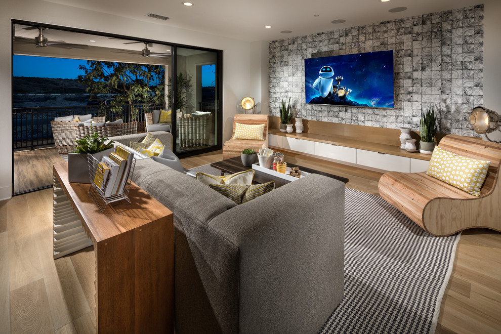 Пример оригинального дизайна: большая двухуровневая гостиная комната в современном стиле с белыми стенами, паркетным полом среднего тона и телевизором на стене без камина