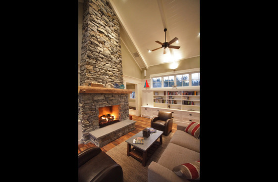 Cette image montre une salle de séjour traditionnelle de taille moyenne et ouverte avec un mur vert, une cheminée standard et un manteau de cheminée en pierre.