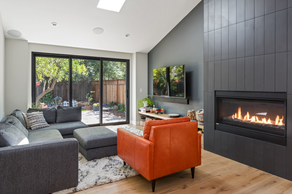 Modernes Wohnzimmer mit grauer Wandfarbe, hellem Holzboden, TV-Wand und beigem Boden in San Francisco