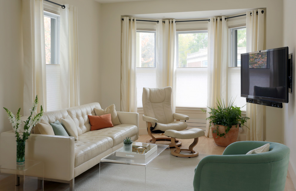 Modelo de sala de estar cerrada tradicional renovada de tamaño medio sin chimenea con suelo de madera clara, televisor colgado en la pared, paredes beige y suelo beige