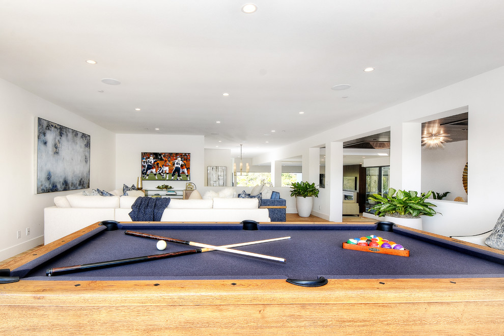 Photo of a large coastal open plan games room in Orange County with a game room, light hardwood flooring and a wall mounted tv.