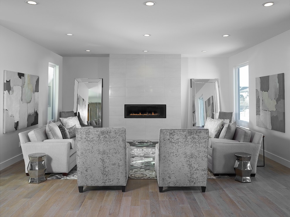 This is an example of a large contemporary open plan games room in Edmonton with grey walls, medium hardwood flooring, a ribbon fireplace and a tiled fireplace surround.