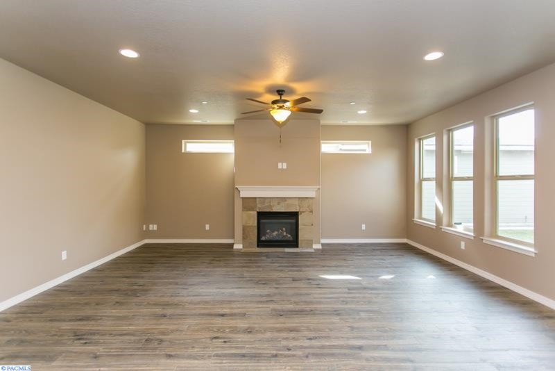 Inspiration for a medium sized traditional open plan games room in Seattle with beige walls, medium hardwood flooring, a standard fireplace and a tiled fireplace surround.