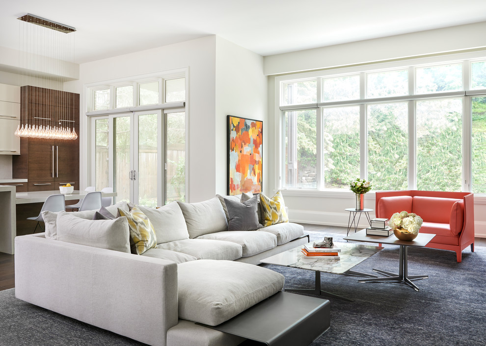 Modelo de sala de estar abierta moderna grande con paredes blancas, suelo de madera oscura, suelo marrón y alfombra