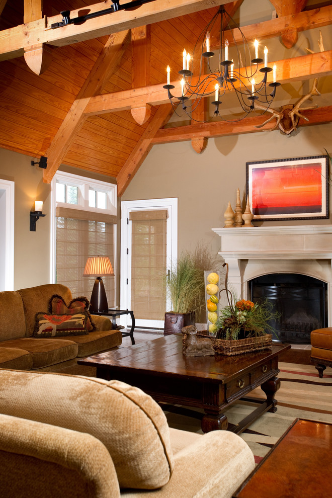 Modelo de sala de estar tipo loft bohemia grande sin televisor con paredes beige, suelo de madera oscura, todas las chimeneas y marco de chimenea de madera