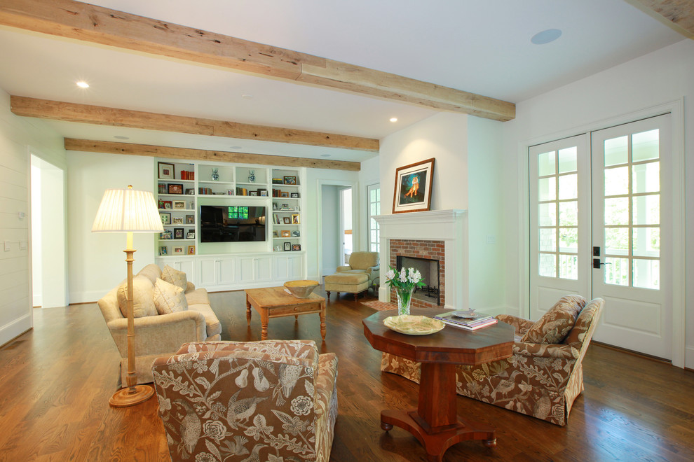 Exemple d'une salle de séjour chic ouverte avec un mur blanc, un sol en bois brun, une cheminée standard et un manteau de cheminée en brique.