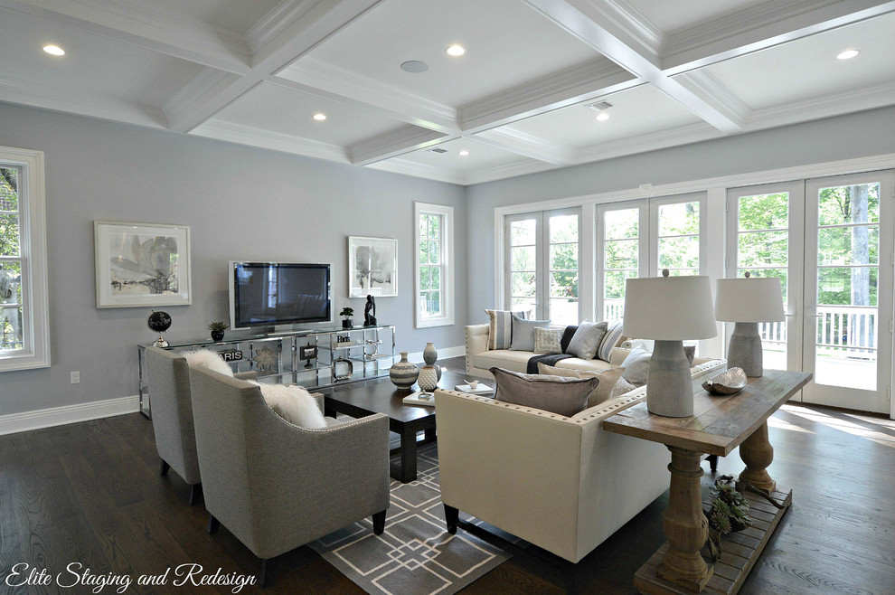 Modelo de sala de estar abierta clásica renovada grande con paredes grises y suelo de madera oscura