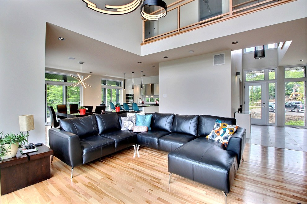 Esempio di un soggiorno moderno di medie dimensioni e aperto con pareti beige e parquet chiaro