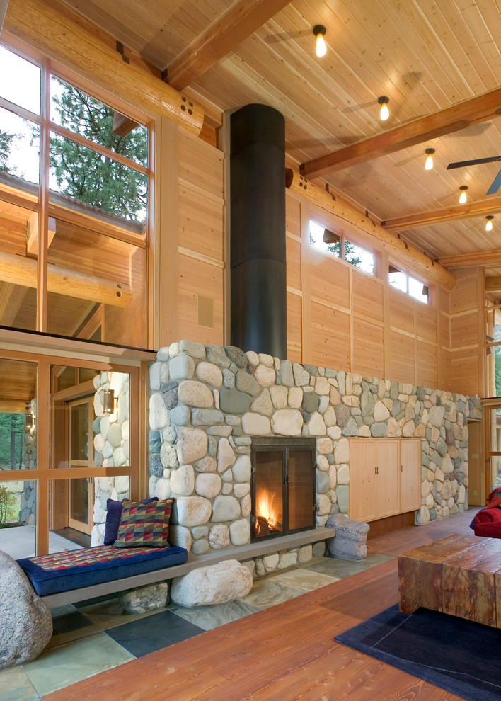Aménagement d'une salle de séjour contemporaine avec un mur beige, un sol en bois brun, une cheminée standard et un manteau de cheminée en pierre.