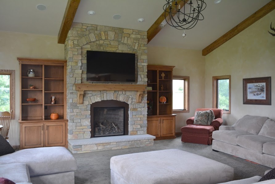 Inspiration for a medium sized traditional open plan games room in Milwaukee with beige walls, carpet, a standard fireplace, a stone fireplace surround and a wall mounted tv.