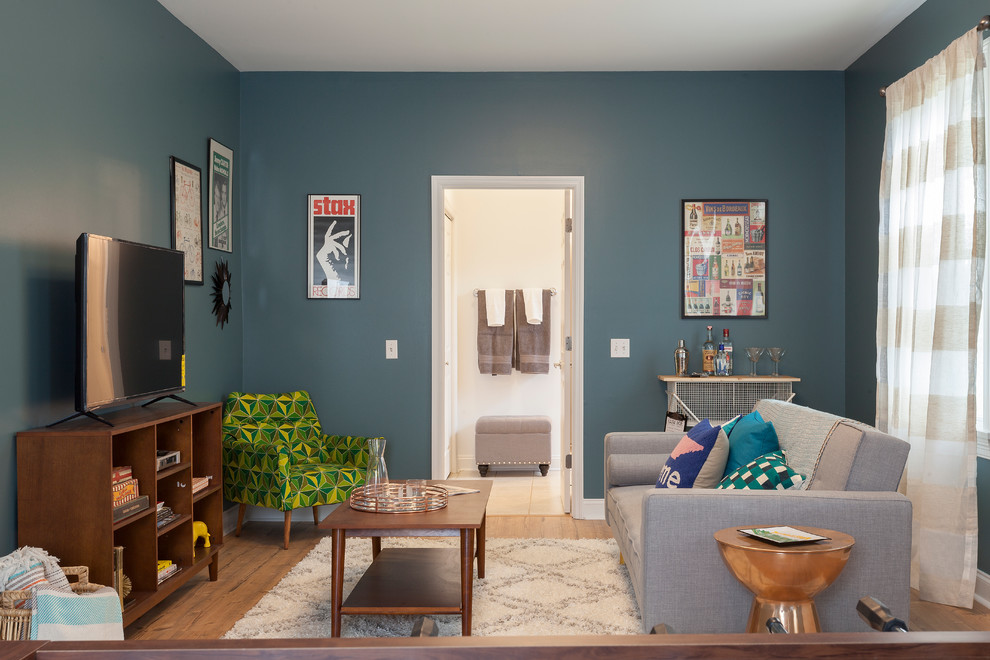 На фото: изолированная комната для игр среднего размера в стиле неоклассика (современная классика) с синими стенами, полом из винила и отдельно стоящим телевизором с