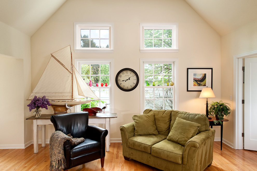 Modelo de sala de estar tipo loft tradicional de tamaño medio con paredes beige y suelo de madera clara