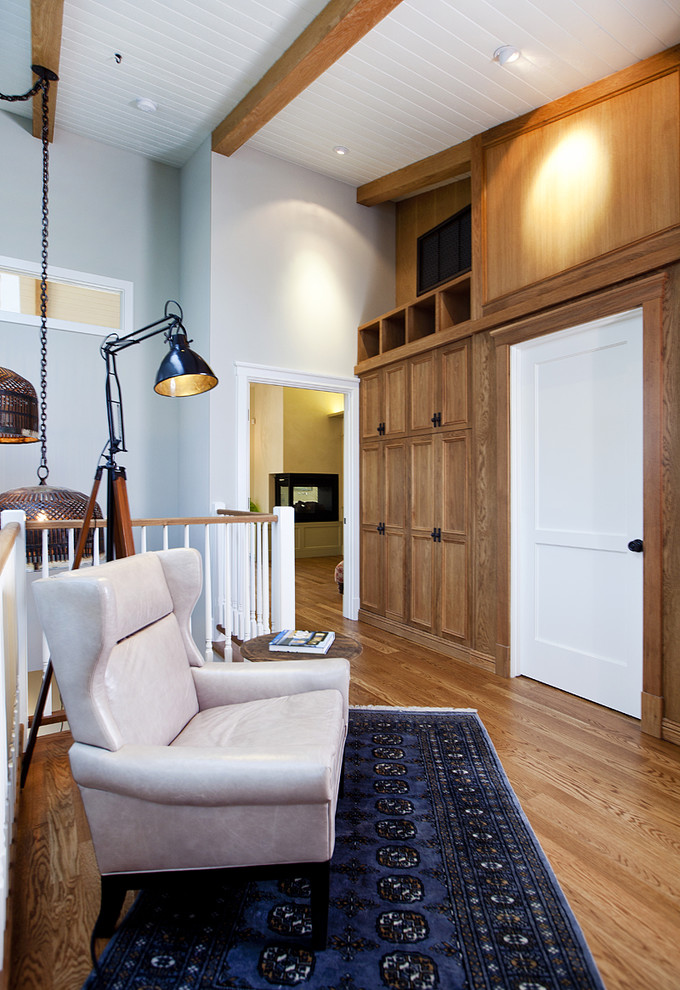 Свежая идея для дизайна: маленькая двухуровневая гостиная комната в современном стиле с синими стенами, паркетным полом среднего тона, телевизором на стене и коричневым полом без камина для на участке и в саду - отличное фото интерьера